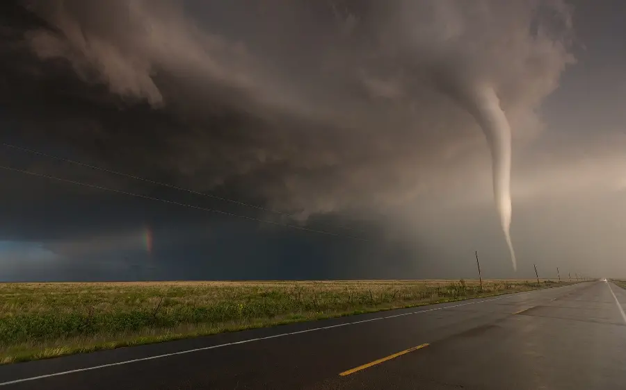 Amazing picture of a tornado and a rainbow above the street
