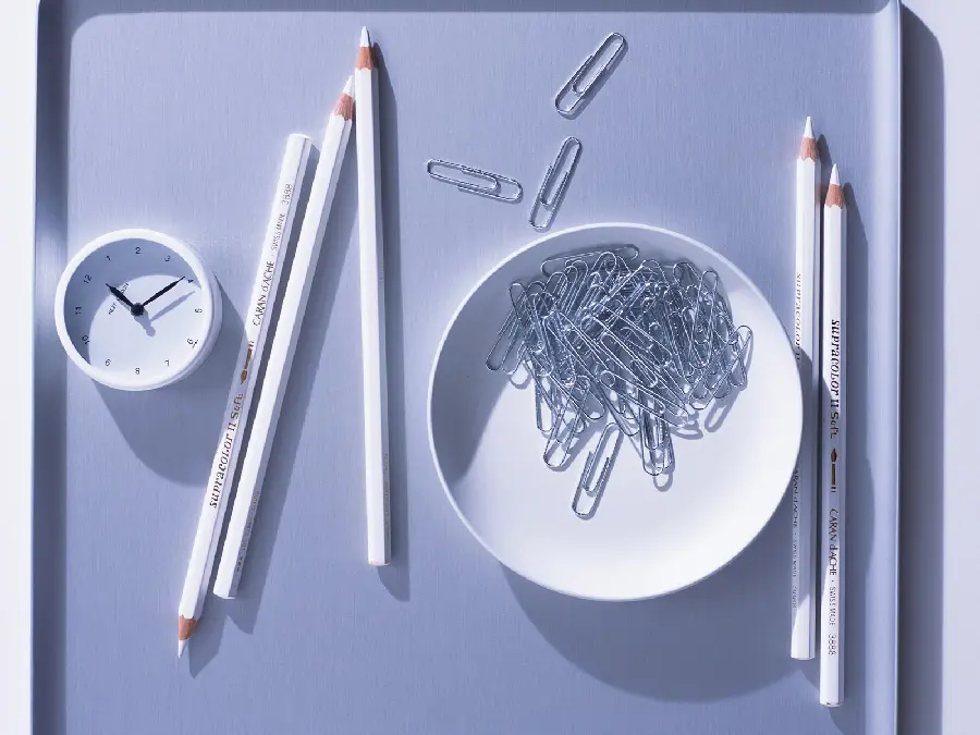 Soothing wallpaper of a pencil, paper clip, clock in a dreamy white color 