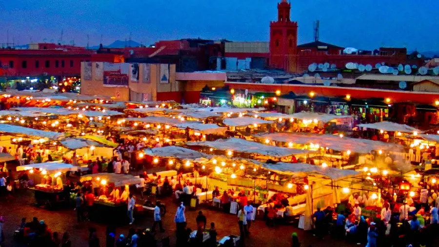 The crowded market of Morocco at night with impressive illuminations