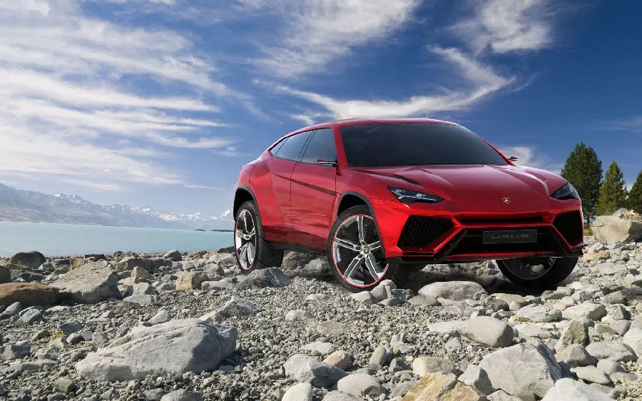 Red Lamborghini SUV on top of the mountain with blue sky