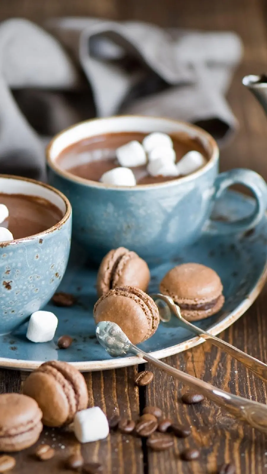 A hearty picture of a cup of coffee and chocolate macaron