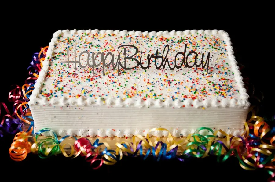 A beautiful picture of a cute rectangular cake with the caption Happy Birthday in English