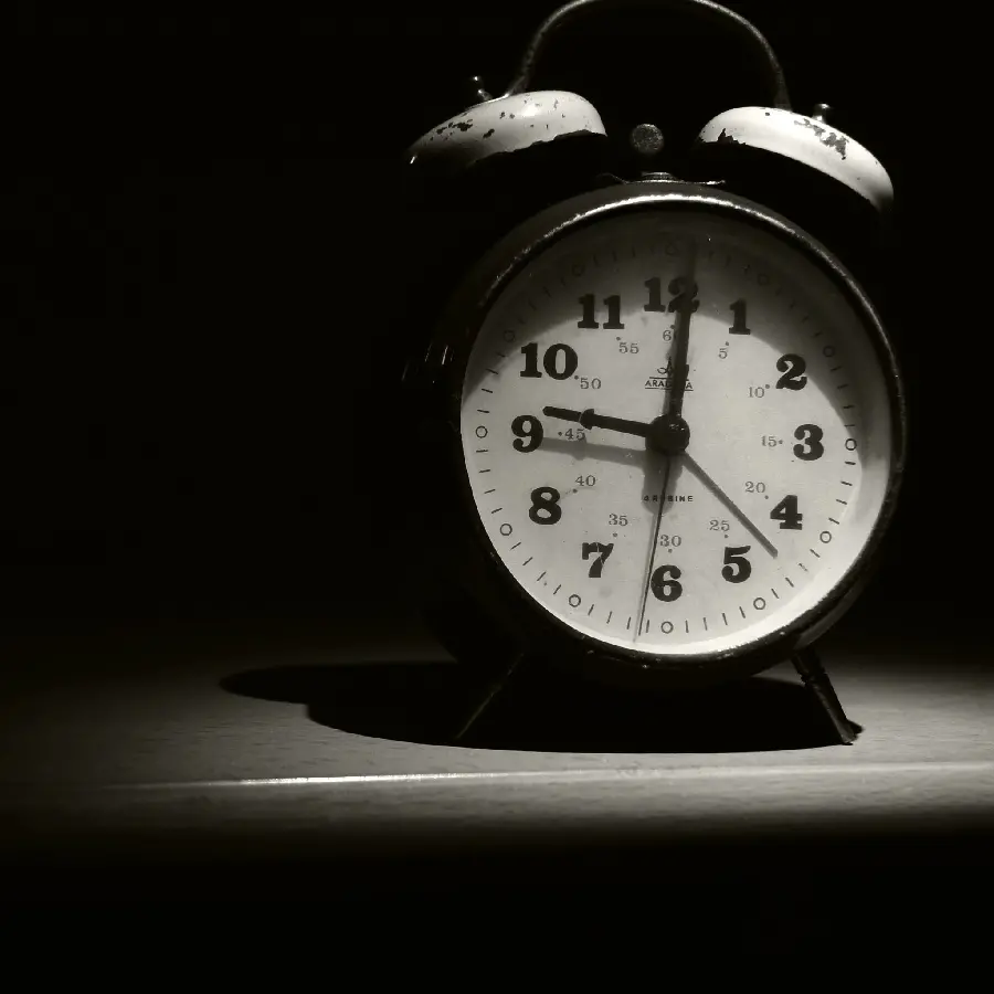 Dark and conceptual background with the image of an old alarm clock for the desktop