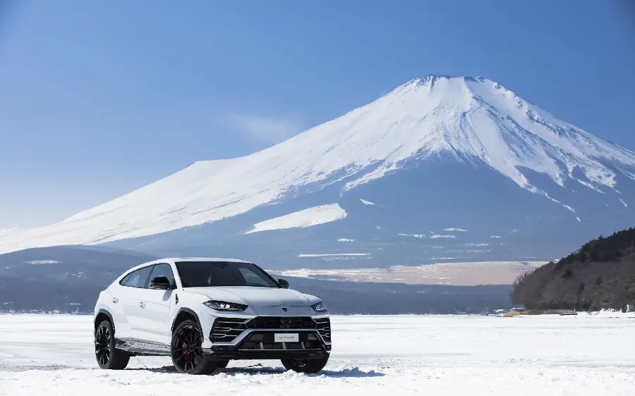 White Lamborghini SUV wallpaper next to a beautiful volcanic mountain