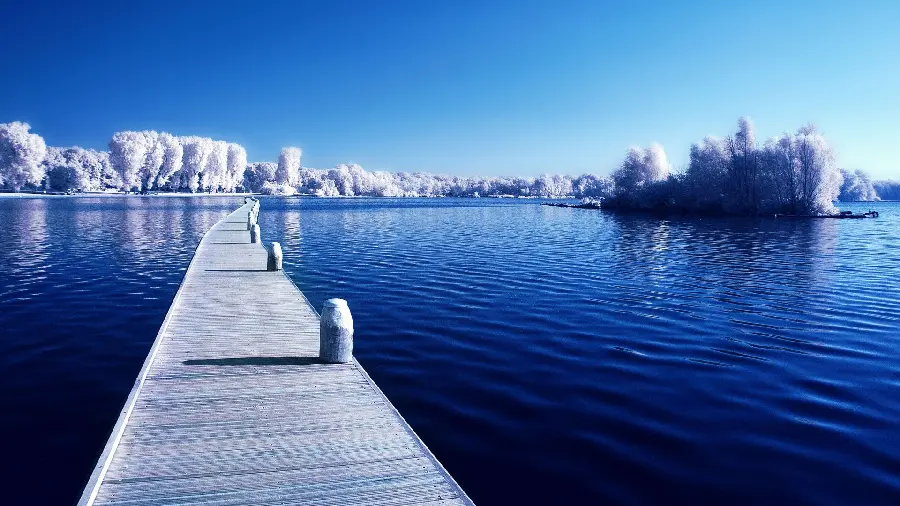 Wooden pier with a blue background of the sea and sky and a background image of a wooden pier and a lake view