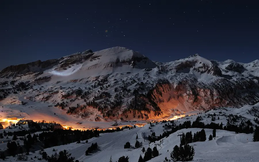 Amazing background of snowy mountains in the dark night