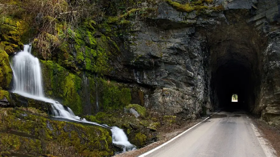 Soothing background of a small clear waterfall at the entrance to the tunnel