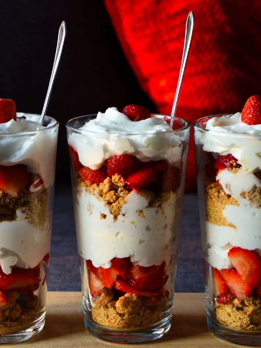 Photo of delicious glass cheesecake decorated with cream and strawberries