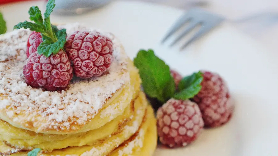 A mouthwatering image of delicious pancakes for breakfast with a berry decoration