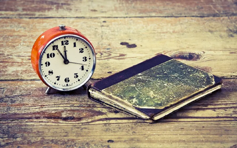 A round clock and an old notebook in a beautiful view for an artistic profile