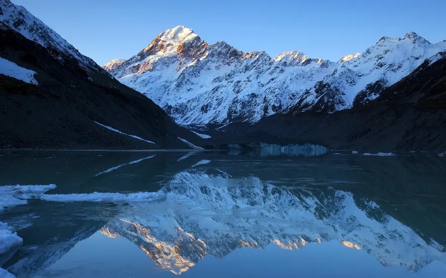 Background of the reflection of the image of a snowy mountain in the water for Windows 11