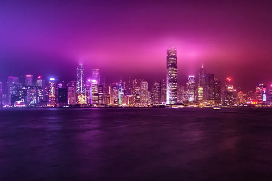 Purple background image of many illuminated buildings at night