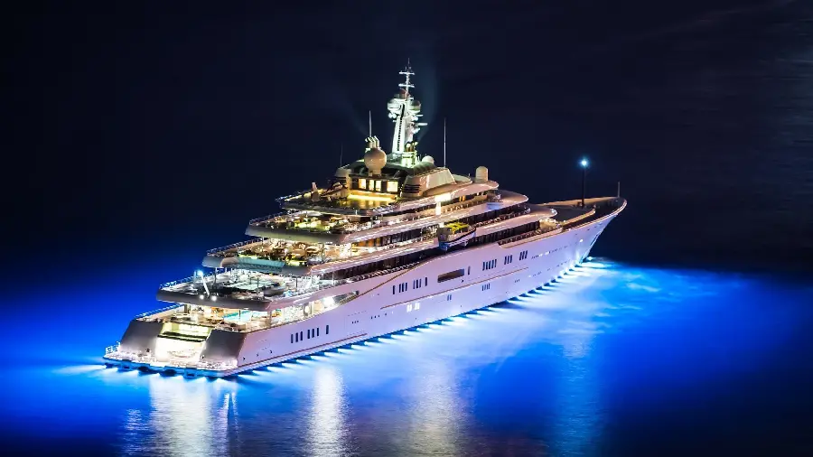 Photo of a large yacht at night with bright lights