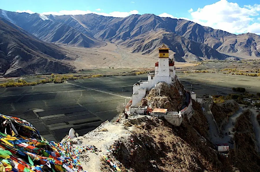 A white photo of a temple in Tibet in the high mountains