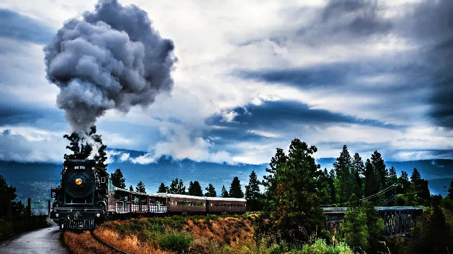 Download a laptop background with a roaring steam locomotive on the track