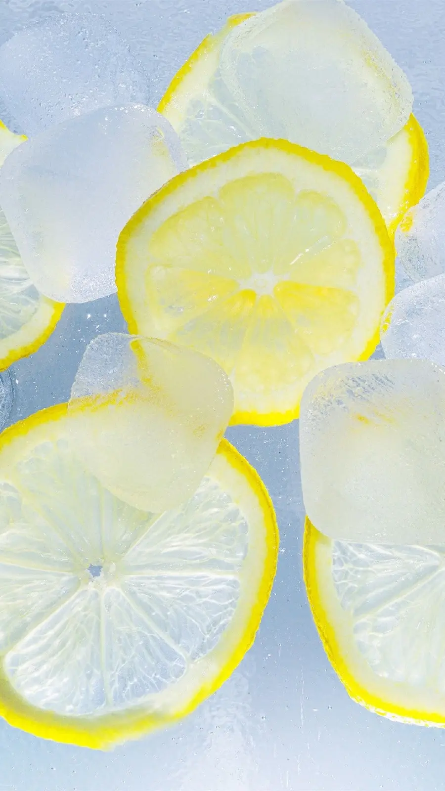 Stock photo of sour yellow lemons with ice cubes 