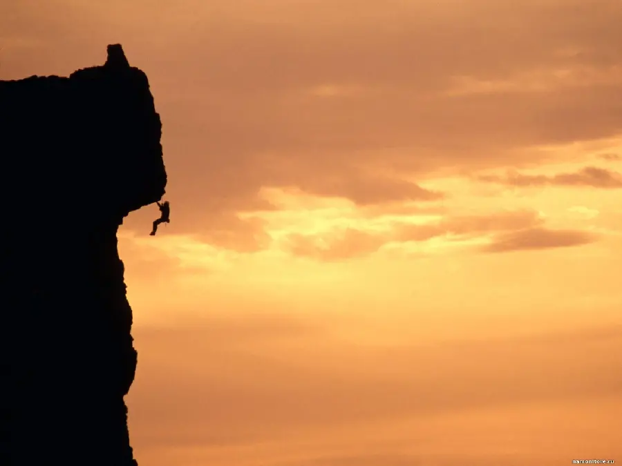 Risky and dangerous image of a rock climber hanging from a cliff hd