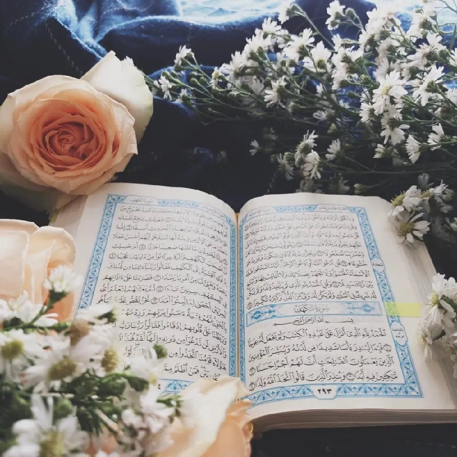 Amazing photo of the Holy Quran with beautiful and spectacular flowers next to it 