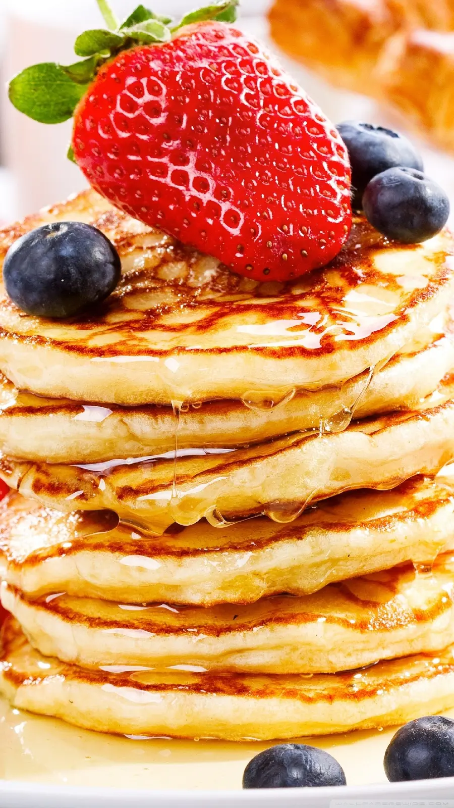 Image of delicious and fluffy honey strawberry and blueberry pancakes