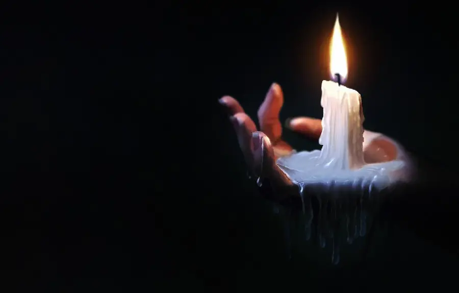 Image of a burning candle on the hand for condolences to the bereaved HD 