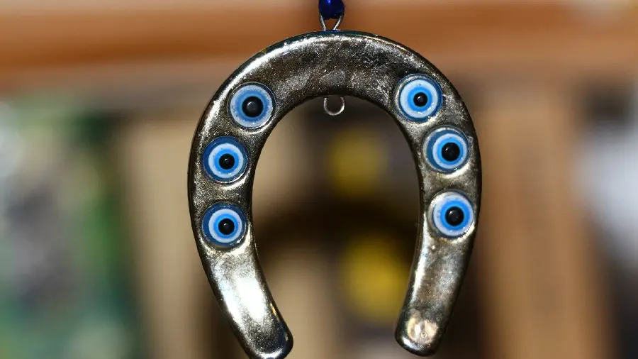 Interesting image of a metal pendant with six eyes attached to it