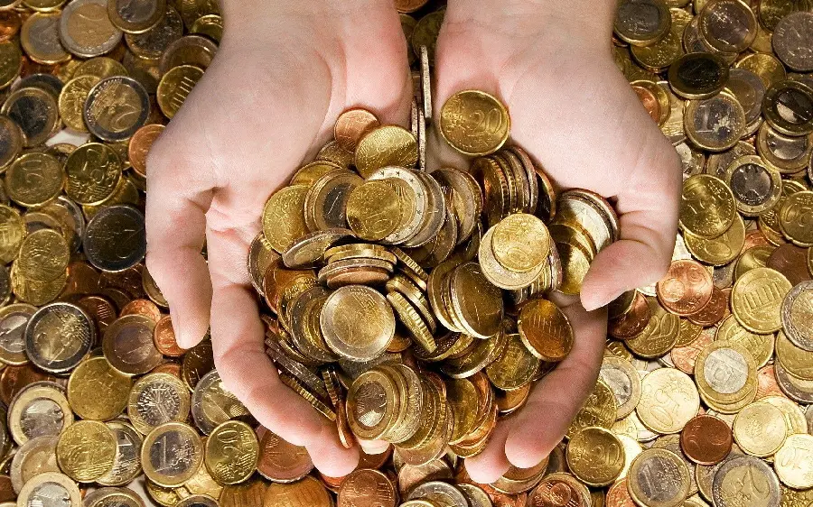 Wallpaper Gold coins held in hand in the background 