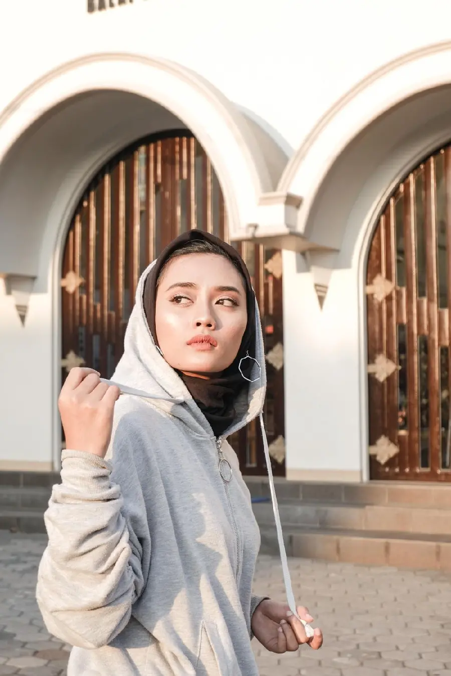 Background of a girl with a hijab, athletic, in front of a luxury building