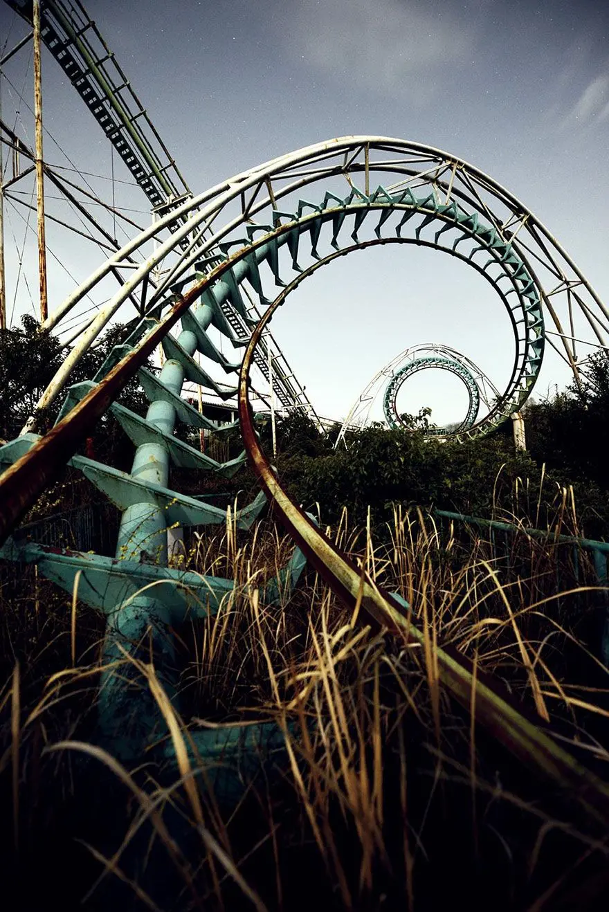 Wallpaper of broken roller coaster in abandoned amusement park 