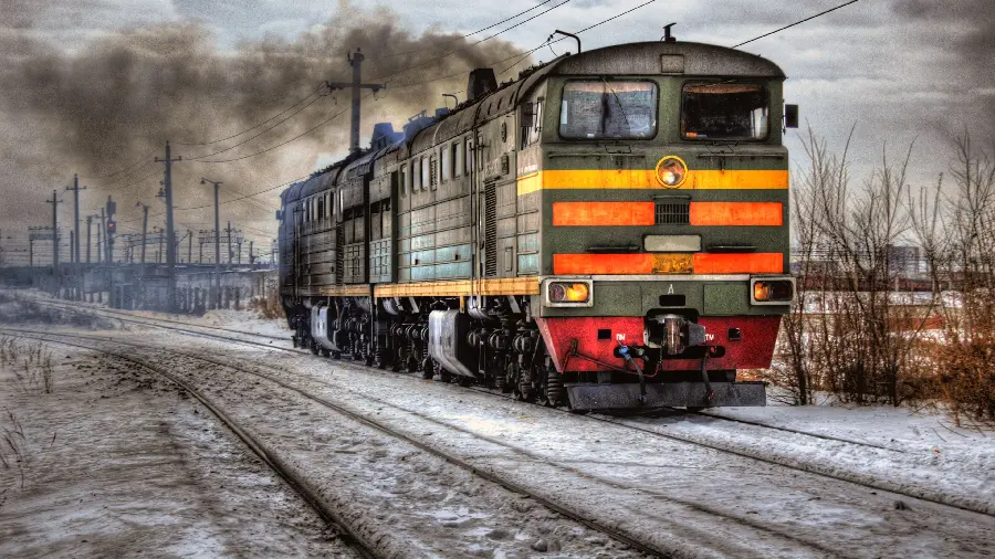 Photo of a large and heavy locomotive with an interesting colored body in winter