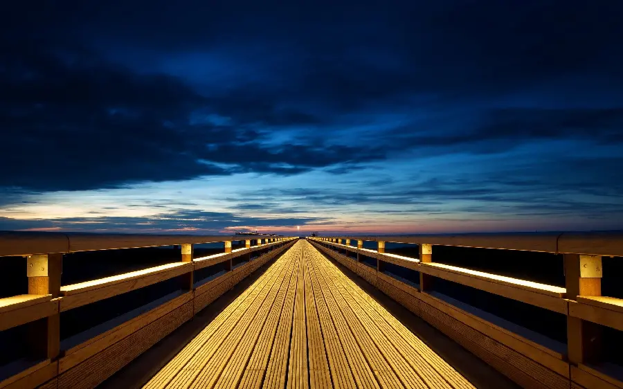 A pleasant stock photo of an endless wooden bridge at sunrise