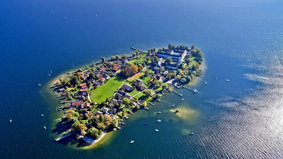 A spectacular wallpaper of an island in the middle of open water with many houses