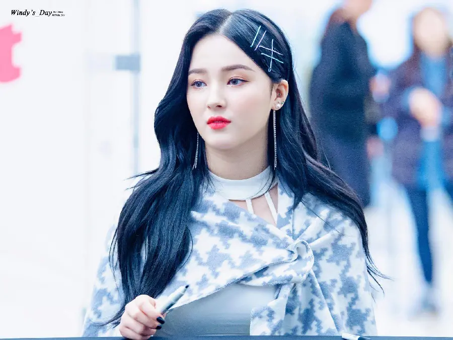 Background photo of Nancy with a good figure in a stylish dress and a pen in her hand