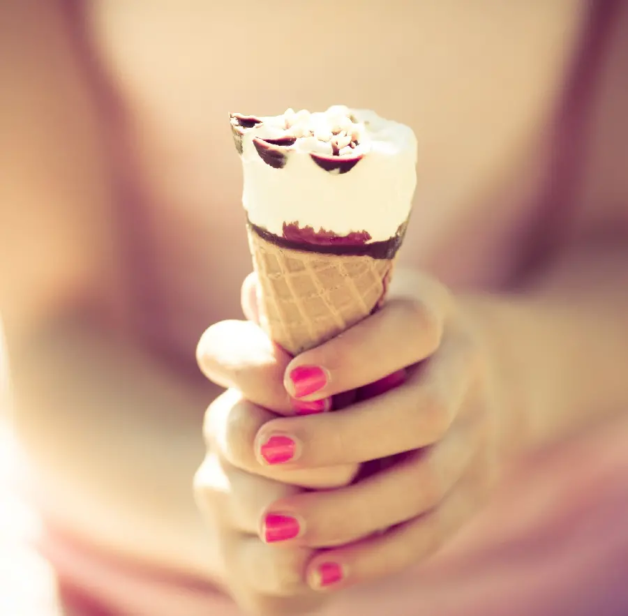 Download the most viewed image of a cone ice cream in a girl's hand with beautiful red nail polish