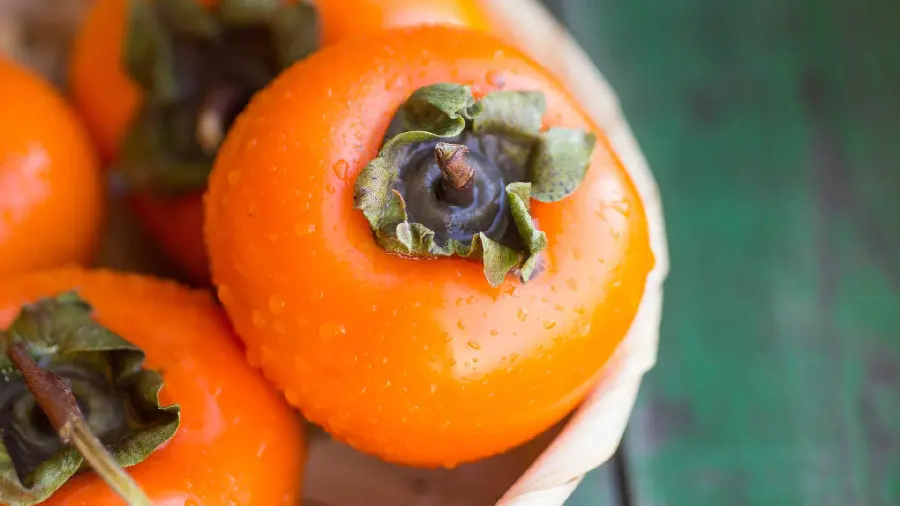 Delicious and pleasant background photo of beautiful persimmons with water droplets