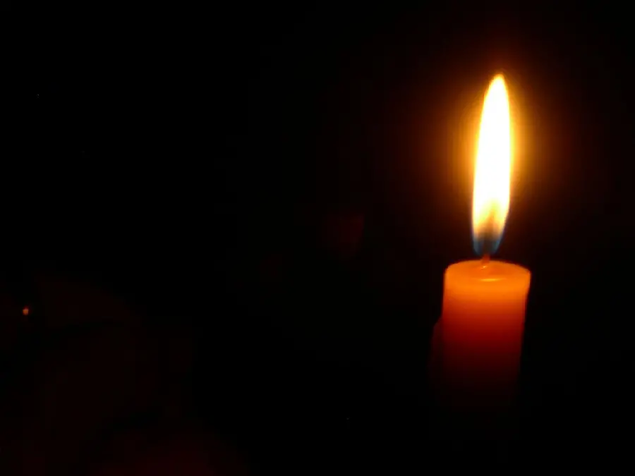 Download a photo of a lit candle on a black background for condolences 