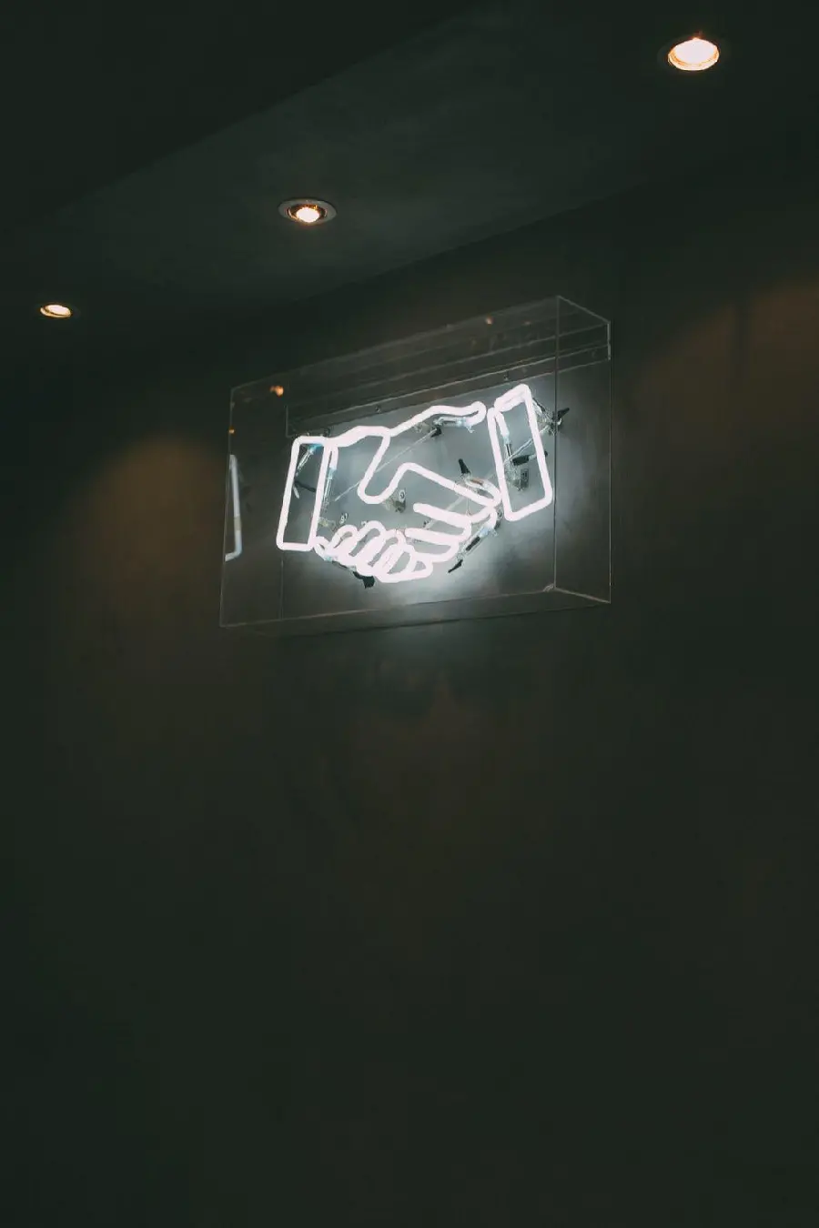 Professional logo design ready for handshake shape mounted on the wall with white light 