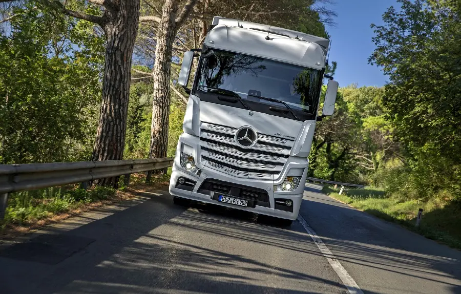 The best computer background of a white Benz Actros truck on a beautiful road