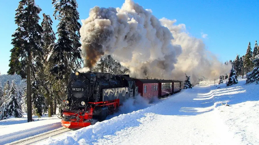 Beautiful background of an old locomotive in the snow with a roar of steam