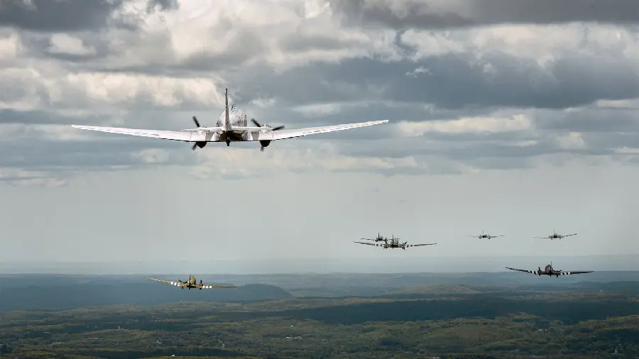 High-quality photo of various old airplanes flying in a cloudy sky