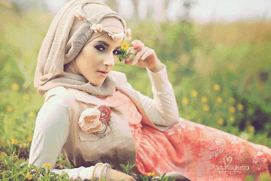 Background of a girl with a hijab lying in a garden of eye-catching flowers