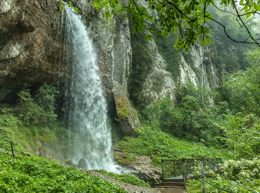 Attractive image of a tall waterfall in a beautiful green forest 