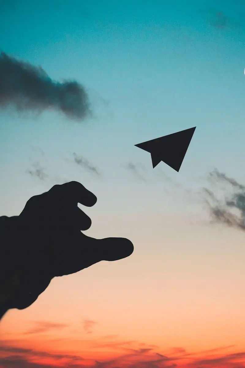 Emotional background of a paper rocket released from the hand in the beautiful sky