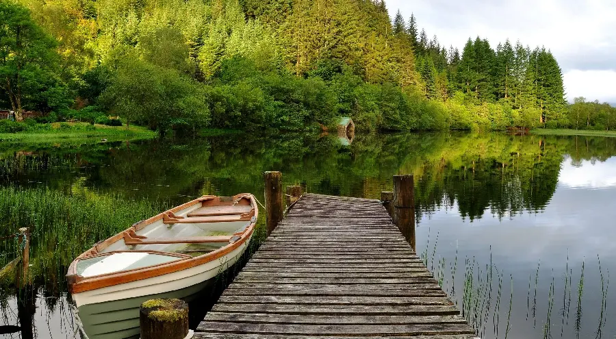 Download Stock Photo of Old Bridge and Wooden Boat by the Lake