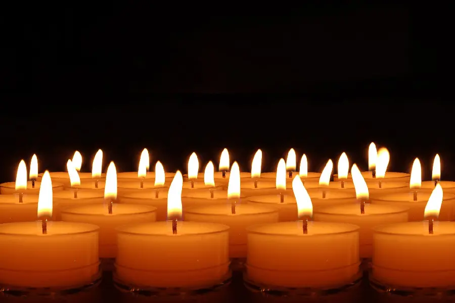 Image of a number of bright yellow candles for condolences and sympathy