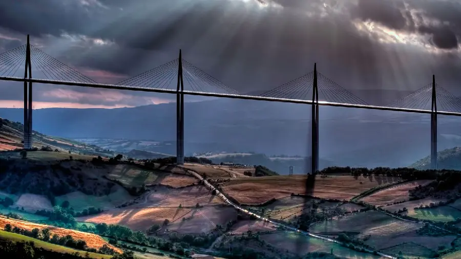 Download a very beautiful picture of the Millau Bridge in a large plain with a cloudy sky