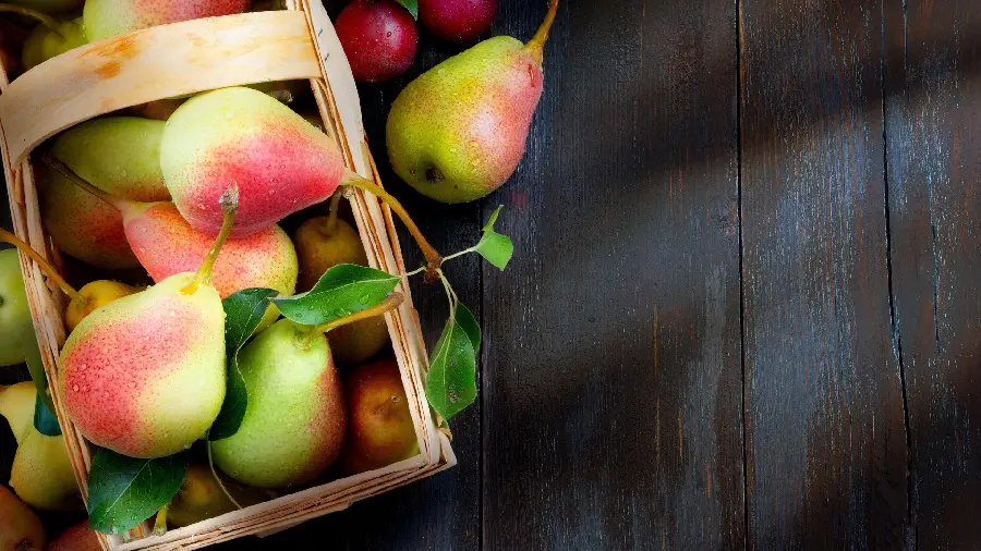 Pleasant and beautiful background of ripe pears in a wooden basket