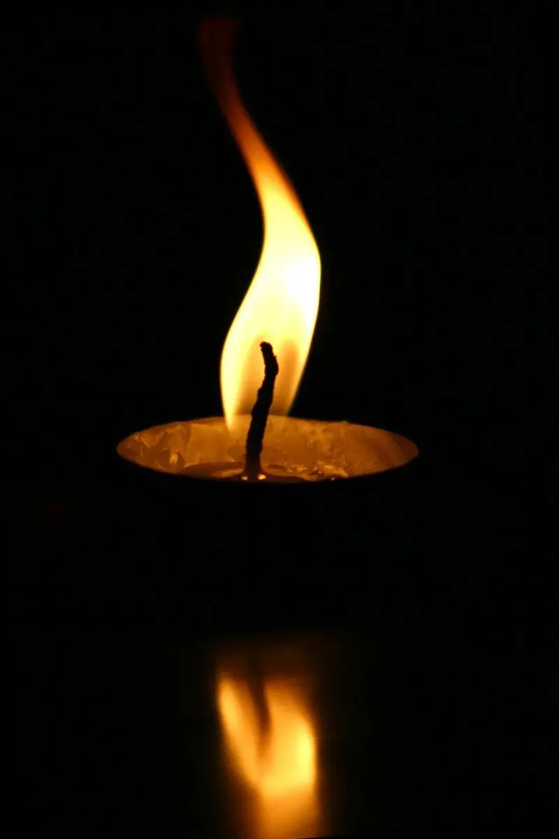 Profile photo of a single lit candle for condolences with a black background for expressing sympathy