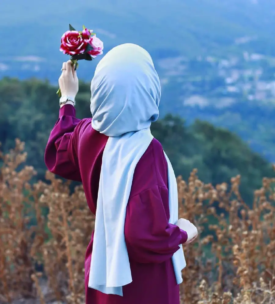 High-quality profile photo of a girl with a hijab from behind with a flower in her hand 