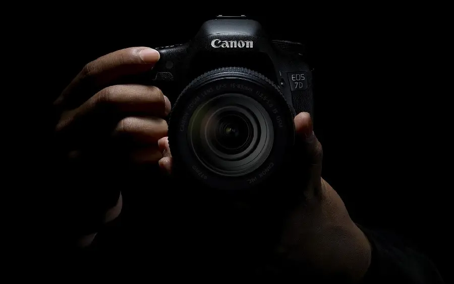 Hand profile photo with camera with dark background suitable for artistic photographers 