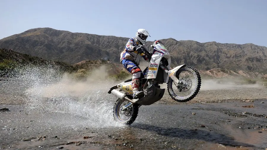Image of a motorcycle crossing a river in the Dakar Rally, the most beautiful show in the world
